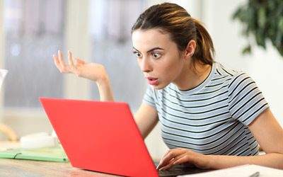 This is an image of a women surprised while going through her website mistakes.