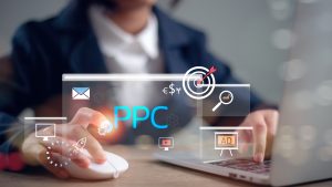 Person using a computer and mouse with digital marketing icons overlaid, including the term 'PPC' and symbols for ads, targeting, email, and analytics, representing online advertising strategy.