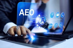 Businessman using a tablet with holographic icons representing Answer Engine Optimization (AEO), symbolizing digital strategy and AI-powered search technologies.