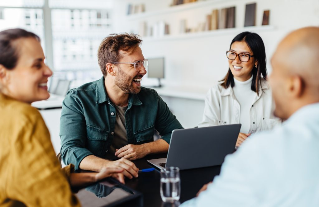 Diverse team of business professionals gathered around a table in a meeting